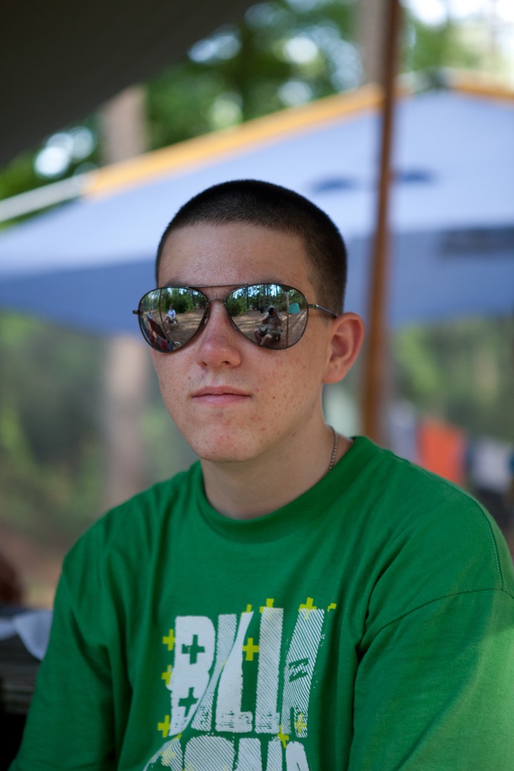 A boy in a green shirt with shades on