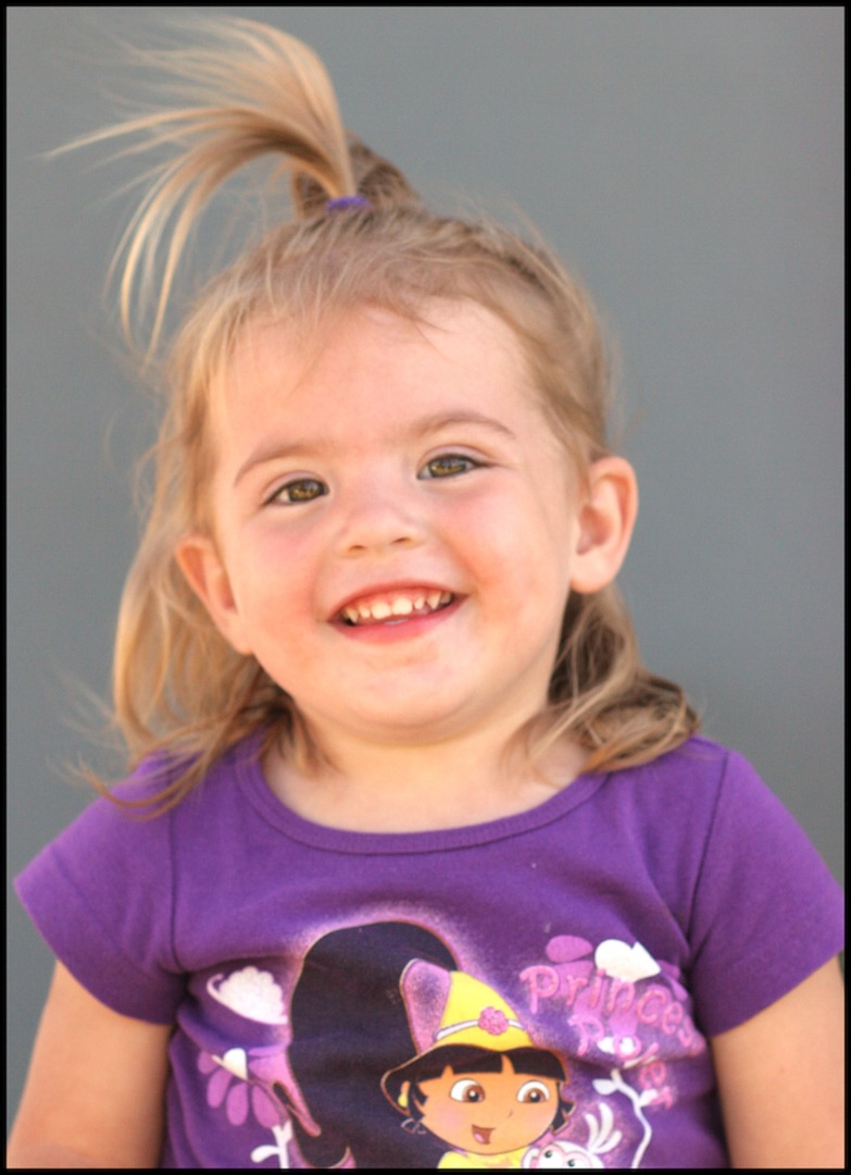 A child in a purple shirt smiling