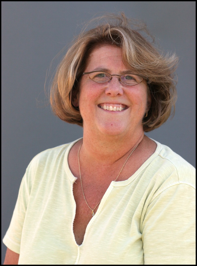 A woman in a yellow shirt smiling