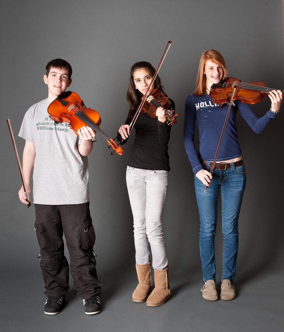 three people holding a violin