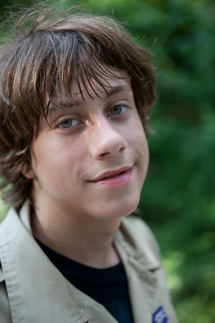 A guy smiling with a green shirt