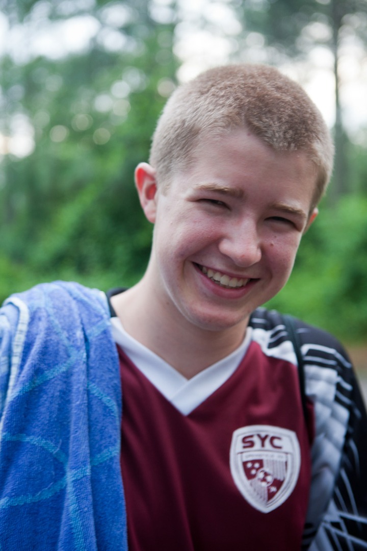 A boy with a blue towel in his shoulder