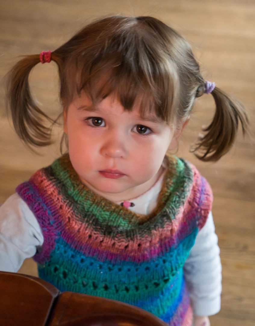 A child in a ponytails frowning