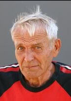 An image of an old man in a red and black shirt